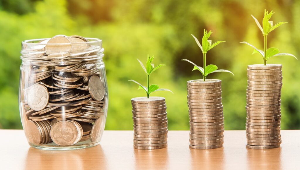Jar of coins beside increasing stacks of coins, illustrating equity growth.